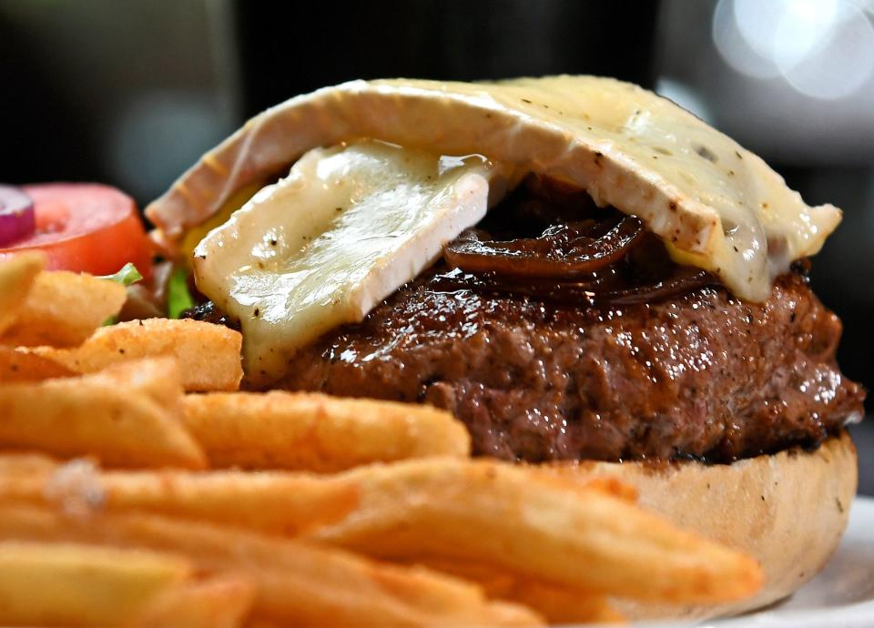 Shakespeare's English Pub's 3550 S Osprey Ave, Sarasota. Shakespeare's English Pub's Caramelized Onion & Brie Burger. Angus beef with sweet balsamic caramelized onions & brie cheese, lettuce, tomato, onion, pickle with a side of fries and a pint of Guinness Stout. THOMAS BENDER/HERALD-TRIBUNE