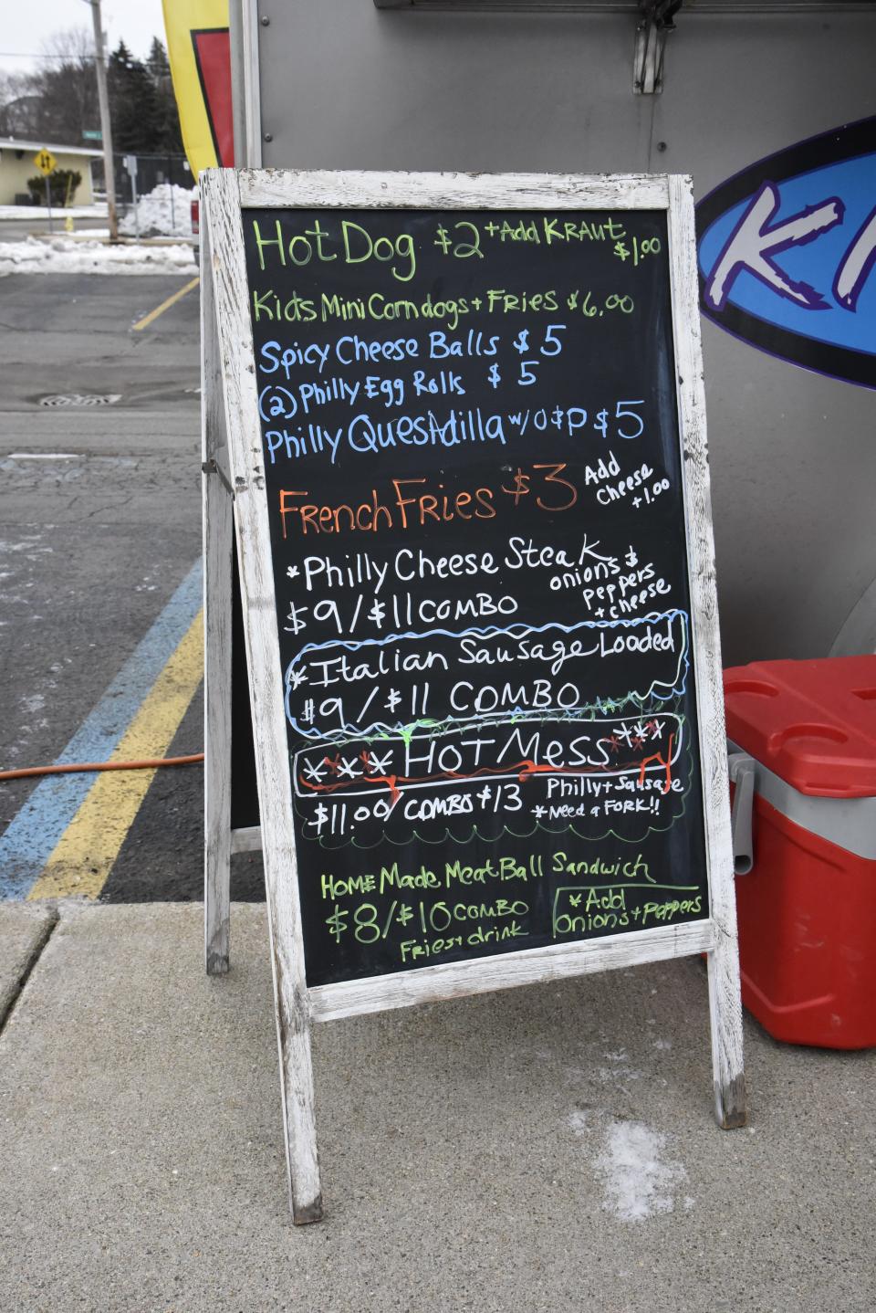 A sandwich board displaying the menu items for Kickin Kurbz mobile kitchen on Friday, Jan. 14, 2022.