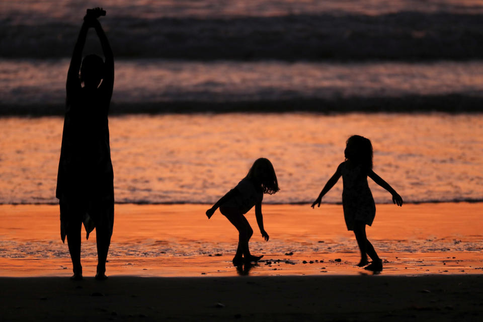 A family plays while cooling off at the beach in Cardiff after sunset during what local media reported to be a record breaking heat wave in Southern California, U.S., October 24, 2017. REUTERS/Mike Blake