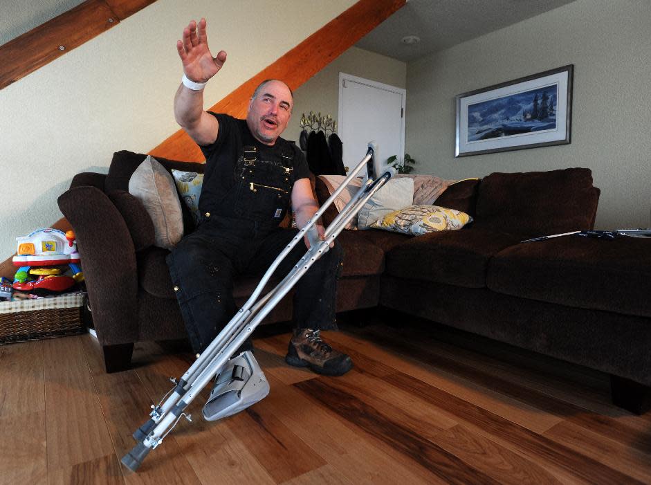 Iditarod musher Scott Janssen describes his overnight ordeal while wearing a boot for his broken foot on Wednesday afternoon, March 5, 2014, at his south Anchorage, Alaska, home. Janssen, an Anchorage undertaker known as the Mushing Mortician, was airlifted off the trail to an Anchorage hospital for treatment for a concussion along with a broken bone. (AP Photo/Anchorage Daily News, Erik Hill)