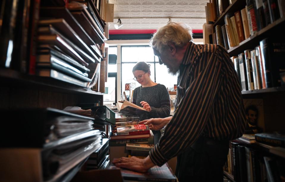 Ray Walsh, 75, owner of the Archives Book Shop and Curious Book Shop, both in East Lansing, helps Alethea Foster of Mason find a book at his Archives Book Shop, Monday, Feb. 5, 2024.