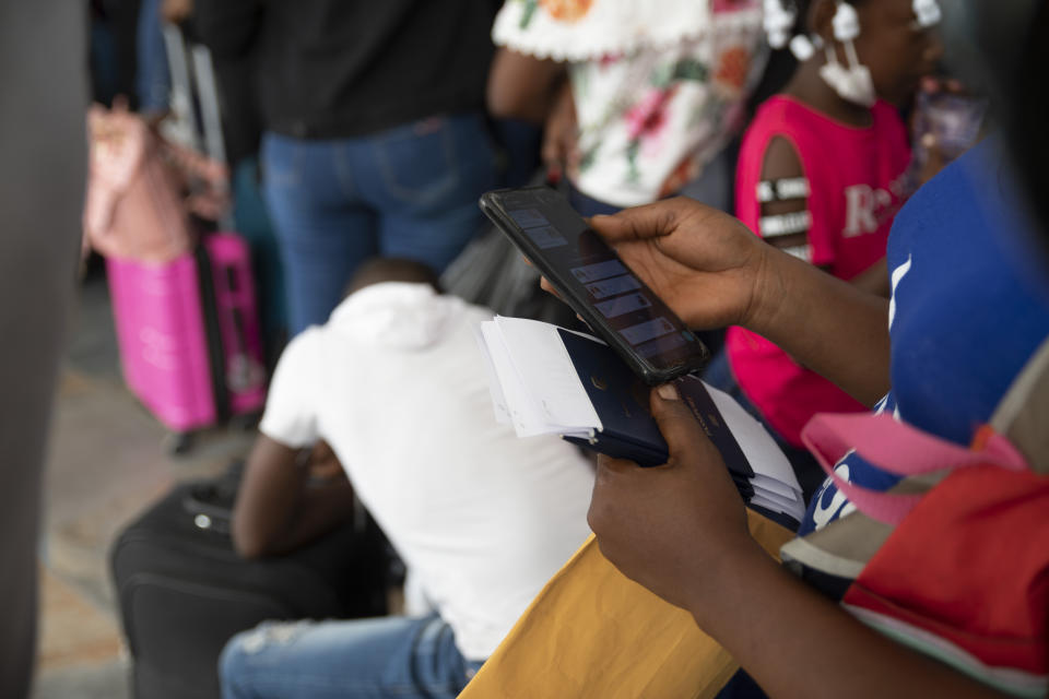 Haitian migrants wait in line to check-in for a flight to Chile, at the Toussaint Louverture International Airport, in Port-au-Prince, Haiti, Sunday, Jan. 30, 2022. Thousands of Haitians in recent months have boarded charter flights to South America, according to flight tracking information and independent verification by The Associated Press in collaboration with the University of California, Berkeley. (AP Photo/Odelyn Joseph)