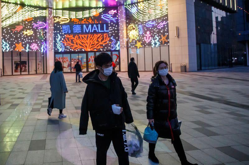 People wear face masks outside a shopping mall in Beijing as the country is hit by an outbreak of the novel coronavirus