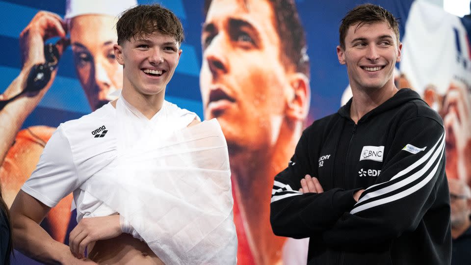 Grousset (right) and an injured Fente-Damers wait for their medals. - Sebastien Bozon/AFP/Getty Images