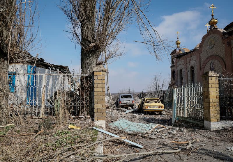 FILE PHOTO: A view shows a residential building, cars and a church damaged by a Russian military strike in the frontline city of Avdiivka