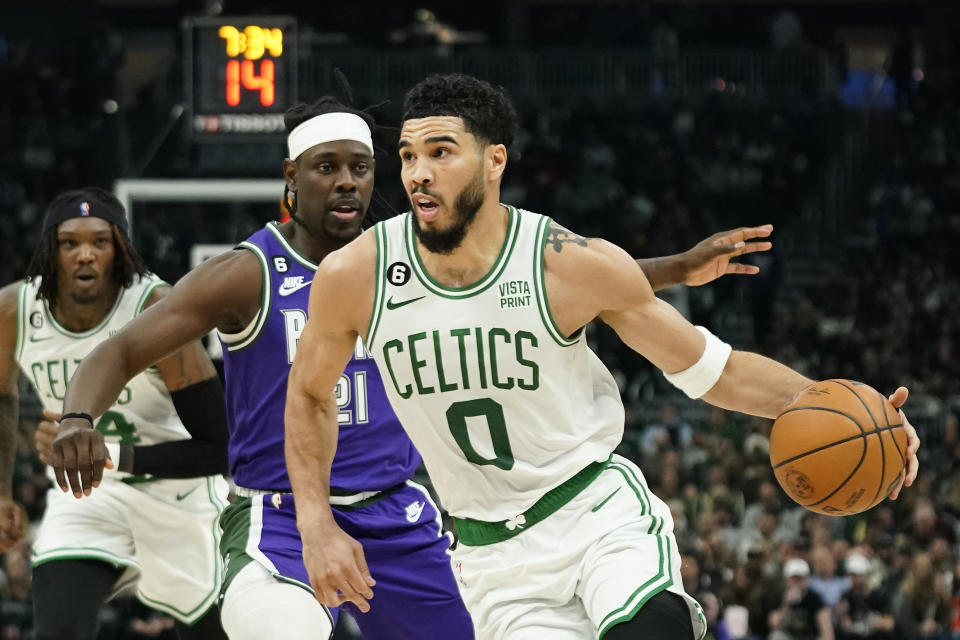 Boston Celtics' Jayson Tatum (0) drives to the basket against Milwaukee Bucks' Jrue Holiday during the first half of an NBA basketball game Thursday, March 30, 2023, in Milwaukee. (AP Photo/Aaron Gash)