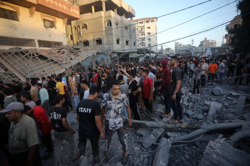 People gather to search for victims following an Israeli strike in Rafah in the southern Gaza Strip, on Monday. While not officially confirmed by Prime Minister Benjamin Netanyahu or any of Israel's emergency wartime cabinet, evidence indicates the IDF has encircled Gaza City as it seeks to isolate Hamas within its main base, which is undergirded by a sprawling network of tunnels. Photo by Ismael Mohamad/UPI