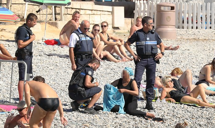 <p>In Nizza verlangten Polizisten von einer Frau, ihren mit einer Kopfbedeckung versehenen Schwimmanzug auszuziehen - zuvor war beschlossen worden, dass Burkinis an öffentlichen Stränden nichts zu suchen hätten. Ende August wurde der Beschluss jedoch zurückgenommen, weil er fundamentale Rechte einschränkte. (Bild: Twitter/FiendTax) </p>