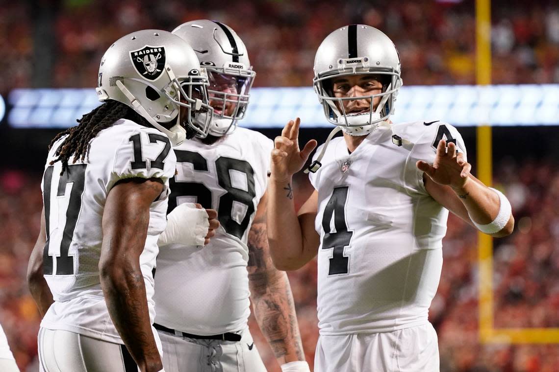 Las Vegas Raiders wide receiver Davante Adams (17) is congratulated by teammates Andre James (68) and Derek Carr (4) after scoring during the first half of an NFL football game against the Kansas City Chiefs Monday, Oct. 10, 2022, in Kansas City, Mo.