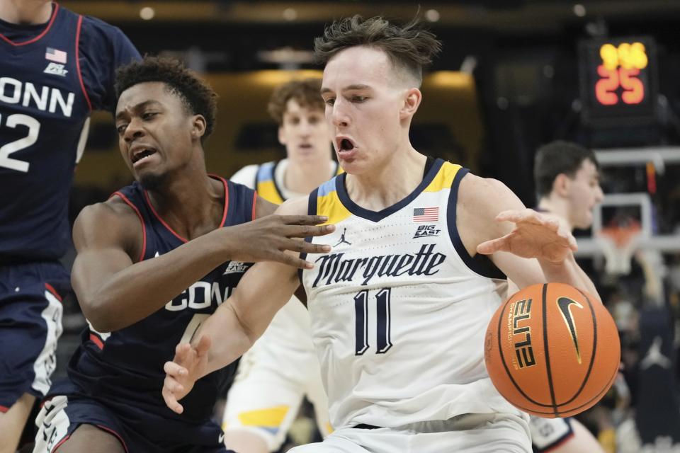 Connecticut's Nahiem Alleyne tries to stop Marquette's Tyler Kolek during the first half of an NCAA college basketball game Wednesday, Jan. 11, 2023, in Milwaukee. (AP Photo/Morry Gash)