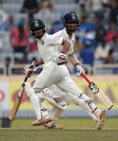 India's Cheteshwar Pujara (R) and Wriddhiman Saha run between the wickets. REUTERS/Adnan Abidi