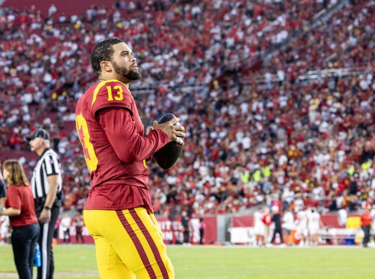 USC quarterback Caleb Williams looks up at the scoreboard while staying loose during a timeout