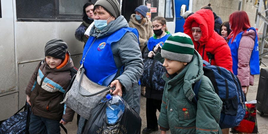 People evacuated from the Donetsk and Luhansk regions, the territory controlled by a pro-Russia separatist in eastern Ukraine, leave a bus to be taken to temporary residences in other regions of Russia, in Taganrog, Russia, Tuesday, Feb. 22, 2022.