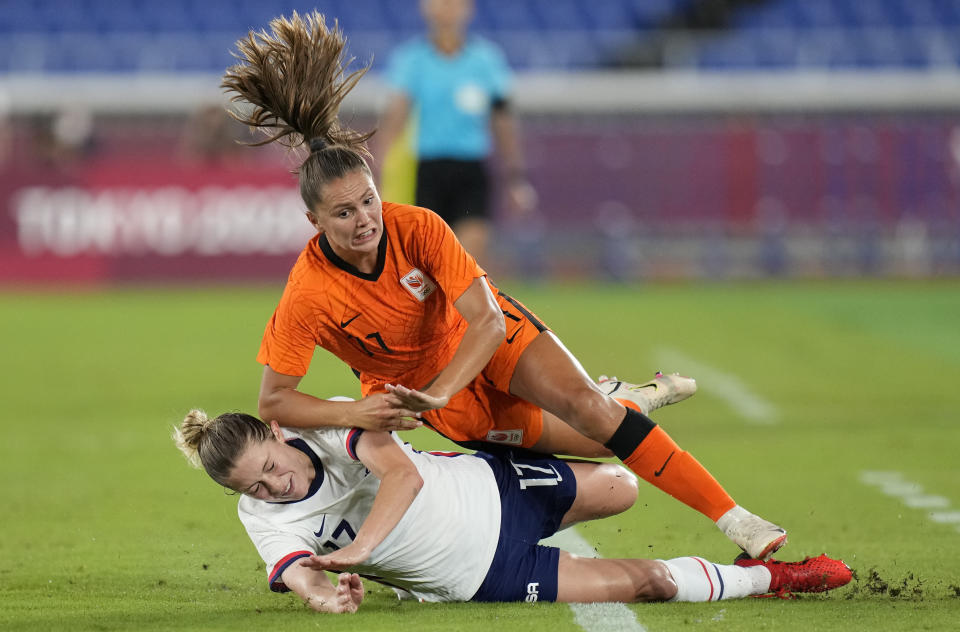 United States' Abby Dahlkemper, left, and Netherlands' Lieke Martens fall while fighting for the ball during a women's quarterfinal soccer match at the 2020 Summer Olympics, Friday, July 30, 2021, in Yokohama, Japan. (AP Photo/Silvia Izquierdo)