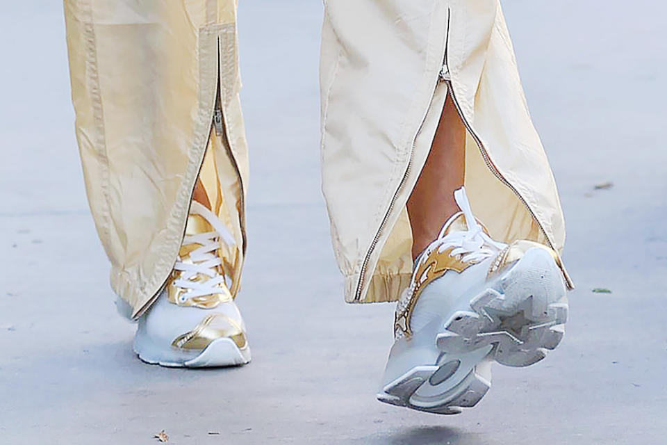 A closer look at Alessandra Ambrosio’s gold and white sneakers. - Credit: SplashNews.com