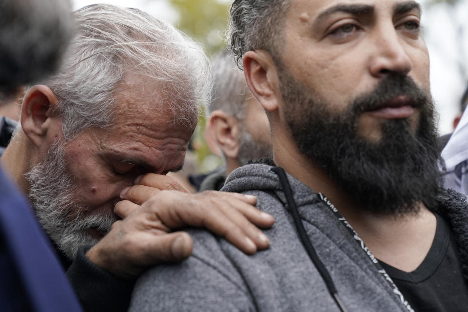 Wadea Al Fayoume's father, Oday Al Fayoume, right, and his uncle Mahmoud Yousef mourn at Wadea's grave in LaGrange, Ill., Monday, Oct. 16, 2023. An Illinois landlord accused of fatally stabbing the 6-year-old Muslim boy and seriously wounding his mother was charged with a hate crime after police and relatives said he singled out the victims because of their faith and as a response to the war between Israel and Hamas. (AP Photo/Nam Y. Huh)