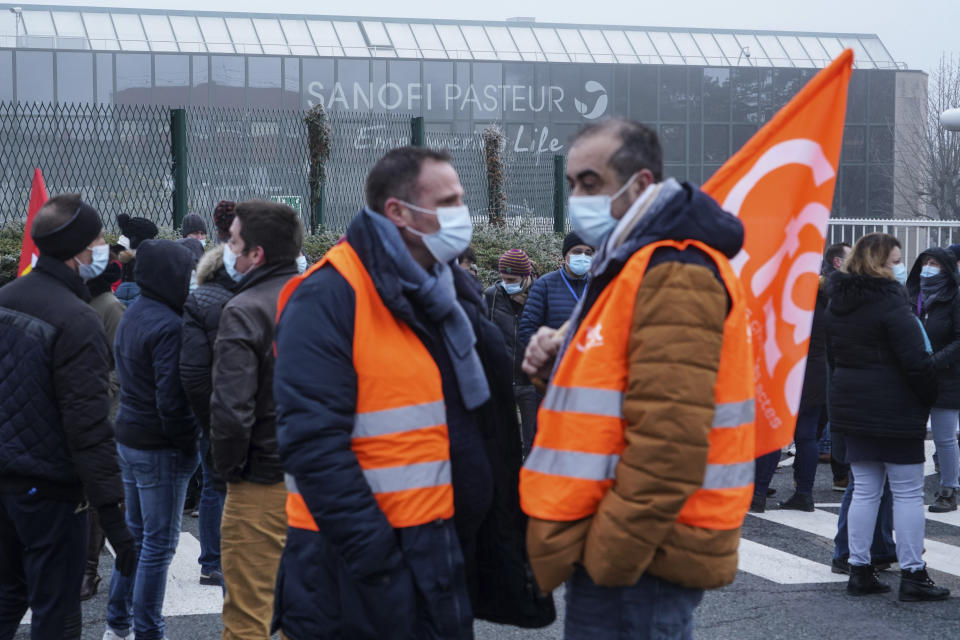 Striking workers gather outside the French pharmaceutical company Sanofi headquarters in Marcy l'Etoile, central France, Tuesday, Jan.19, 2021. Employees of pharmaceutical company Sanofi stage a protest against planned redundancies that they say could slow the fight against the Coronavirus pandemic . Sanofi had been developing Covid vaccines but will not be ready to roll out until late 2021. (AP Photo/Laurent Cipriani)