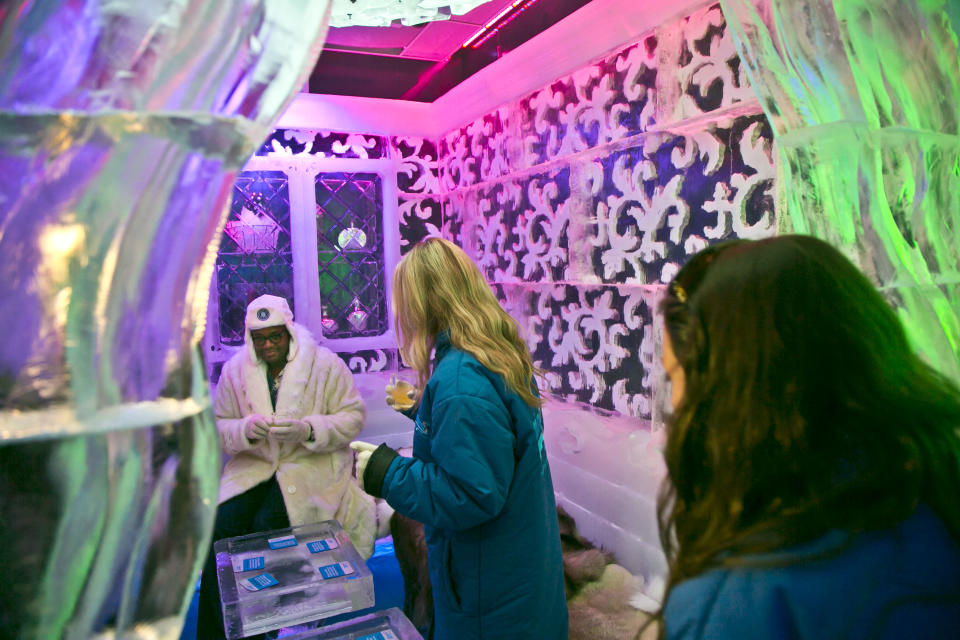 Kevin Parker, left, and other customers explore the VIP room at the Minus 5 ice bar, on Monday, July 8, 2013 in New York. "On a hot day it's exactly what the city needs," said Parker, a real estate broker who plans to book his birthday party at the bar. The city’s first ice bar is now open at the Hilton Hotel on Sixth Avenue. Admission includes Eskimo-style gloves, parkas and boots for the privilege of drinking cocktails in the freezing Minus 5 Ice Bar. (AP Photo/Bebeto Matthews)