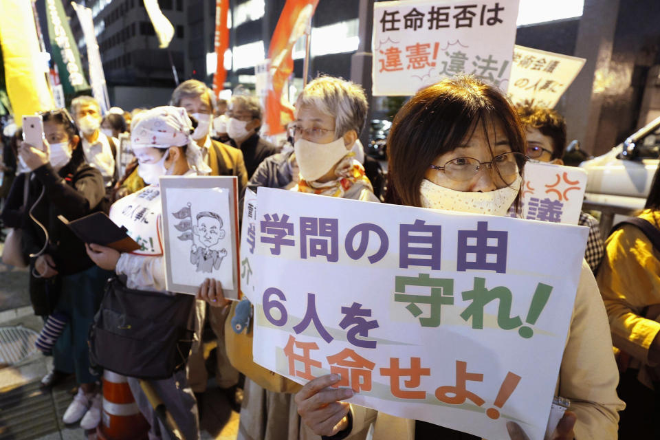People gather outside the prime minister's office in Tokyo on Oct. 6, 2020, during a protest against Japanese Prime Minister Yoshihide Suga's refusal, without explanation, to approve the appointments of six scholars to a government advisory body. This has drawn accusations that Suga is trying to muzzle dissent and impinge on academic freedoms. A sign, bottom right, reads "Protect academic freedoms. Appoint the six scholars." (Kyodo News via AP)