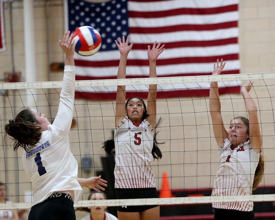 Quincy's Annika Schmitt looks to get her return past Hingham's Kaitlyn Truong and Lizzie Beyer during fourth set action of their match against Hingham at Hingham High on Wednesday, Sept. 21, 2022. Quincy would win 3-2.