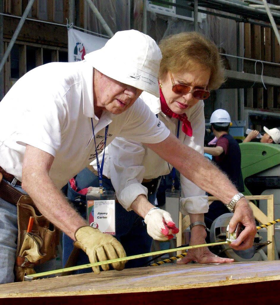 FILE - In this Aug. 6, 2001, file photo former U.S. President Jimmy Carter, left, and his wife Rosalynn help build a house for the Jimmy Carter Work Project 2001, at Asan near Chonan city, south of Seoul, South Korea. Jimmy Carter and his wife Rosalynn celebrate their 75th anniversary this week on Thursday, July 7, 2021.  (AP Photo/Yun Jai-hyoung, File)