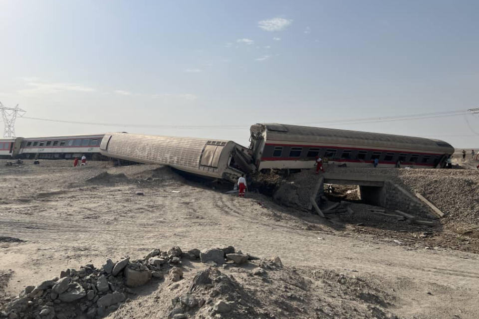 This photo provided by the Iranian Red Crescent Society shows the scene where a passenger train partially was derailed near the desert city of Tabas in eastern Iran, Wednesday, June 8, 2022. (Iranian Red Crescent Society via AP)