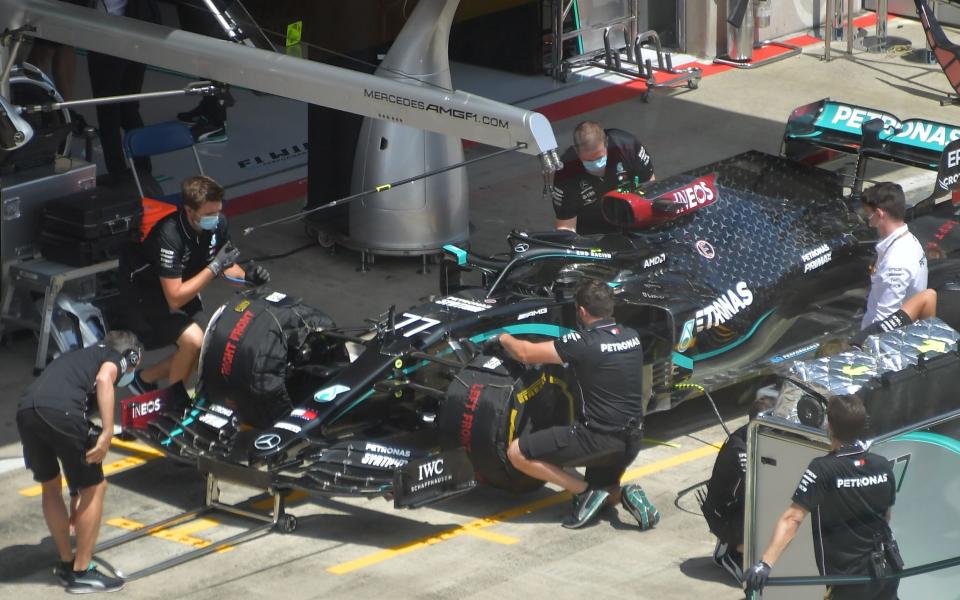 Mechanichs work on Lewis Hamilton's car  - AFP