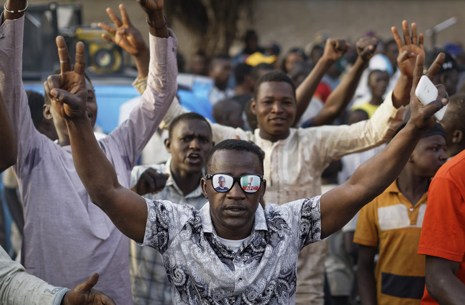 Supporters of President Muhammadu Buhari celebrate the announcement of results favoring his All Progressives Congress (APC) party in their state, anticipating victory, in Kano, northern Nigeria, Monday, Feb. 25, 2019. Nigeria's electoral commission on Monday began announcing official results from the country's 36 states as President Muhammadu Buhari seeks a second term. (AP Photo/Ben Curtis)