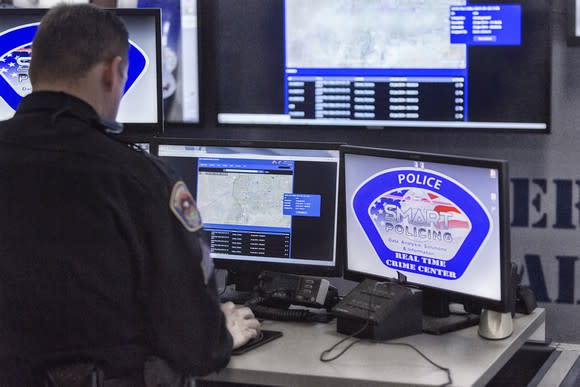 Police officer working with Axon products on a computer.