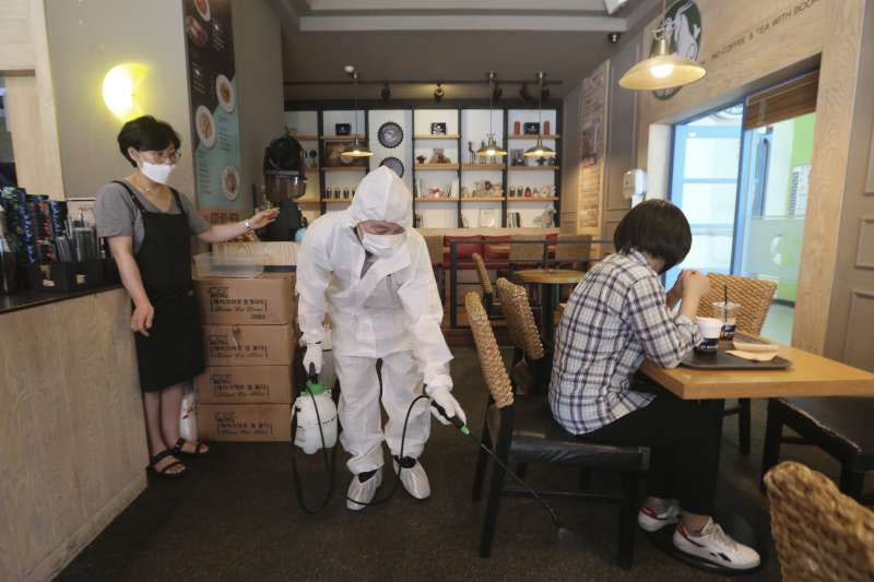 南韓新冠肺炎疫情升溫，防疫人員消毒咖啡廳。（美聯社）