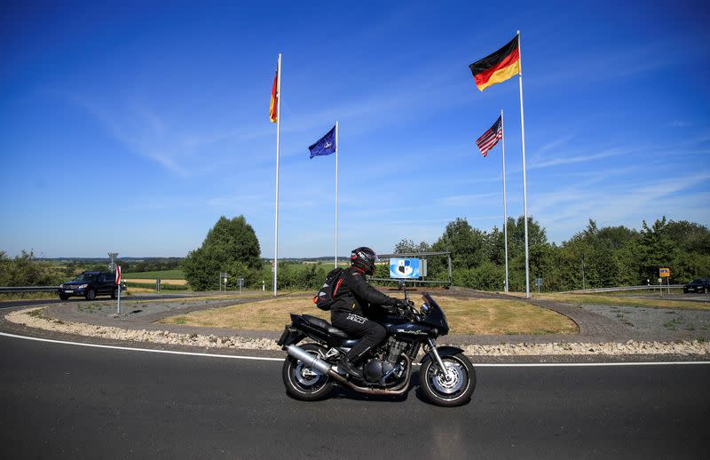 National flags of the U.S. and Germany and a NATO flag flutter in the wind near the main gate of the U.S. Spangdahlem Air Base near Bitburg