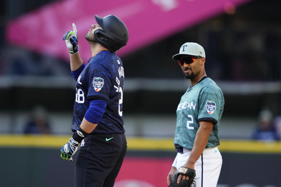 National League's J.D. Martinez, of the Los Angeles Dodgers, reacts on second base as American League's Marcus Semien (2), of the Texas Rangers, watches after Martinez hit a double in the fourth inning during the baseball All-Star baseball Game in Seattle, Tuesday, July 11, 2023. (AP Photo/Lindsey Wasson)