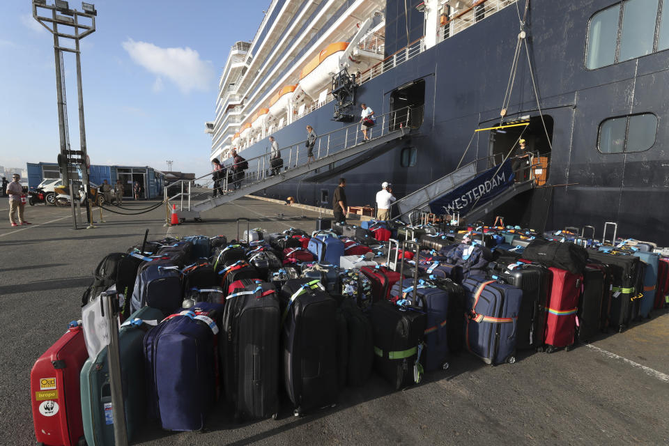 Passenger's luggage from the MS Westerdam, owned by Holland America Line, lay on the ground at the port of Sihanoukville, Cambodia, Saturday, Feb. 15, 2020. After being stranded at sea for two weeks because five ports refused to allow their cruise ship to dock, the passengers of the MS Westerdam were anything but sure their ordeal was finally over. (AP Photo/Heng Sinith)