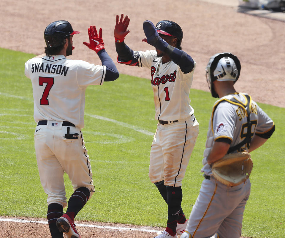 Atlanta Braves batter Dansby Swanson, left, gets a double high-five from teammate Ozzie Albies after hitting a two-RBI home run against the Pittsburgh Pirates during a baseball game Sunday, May 23, 2021, in Atlanta. (Curtis Compton/Atlanta Journal-Constitution via AP)