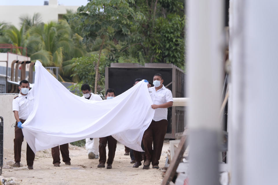 FILE - Police hold a bed sheet in an attempt to block onlookers after an fatal, armed confrontation close to a hotel near Puerto Morelos, Mexico, Nov. 4, 2021. Mexico will deploy a battalion of National Guard troops to its Mayan Riviera in the wake of a spate of shootings that have put the crown jewel of the country’s tourism industry on edge, Defense Secretary Luis Cresencio Sandoval announced Nov. 17, 2021. (AP Photo/Karim Torres, File)