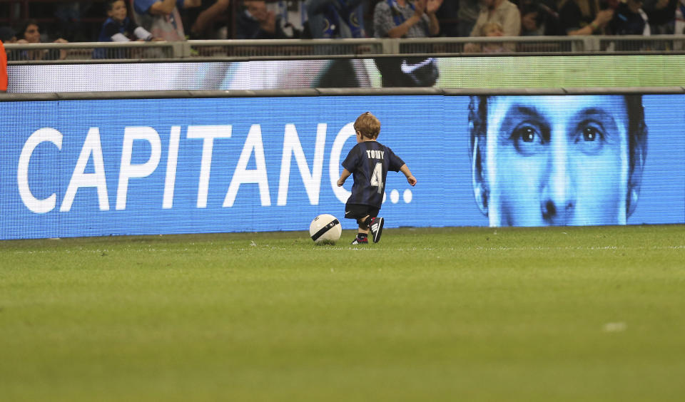 Inter Milan's Javier Zanetti's son plays with a ball at the end of the Serie A soccer match between Inter Milan and Lazio at the San Siro stadium in Milan, Italy, Saturday, May 10, 2014. Zanetti will retire after 19 seasons at Inter, and the stadium was sold out as fans packed in to bid farewell to their 40-year-old captain. (AP Photo/Antonio Calanni)