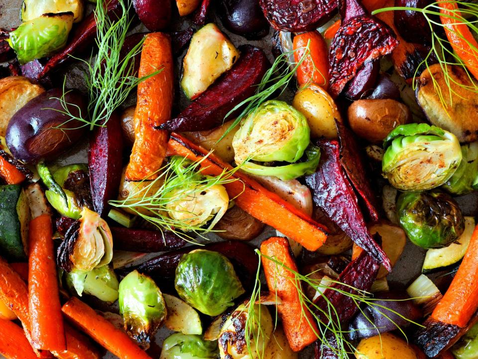 Roasted vegetables flay flat on a baking sheet.