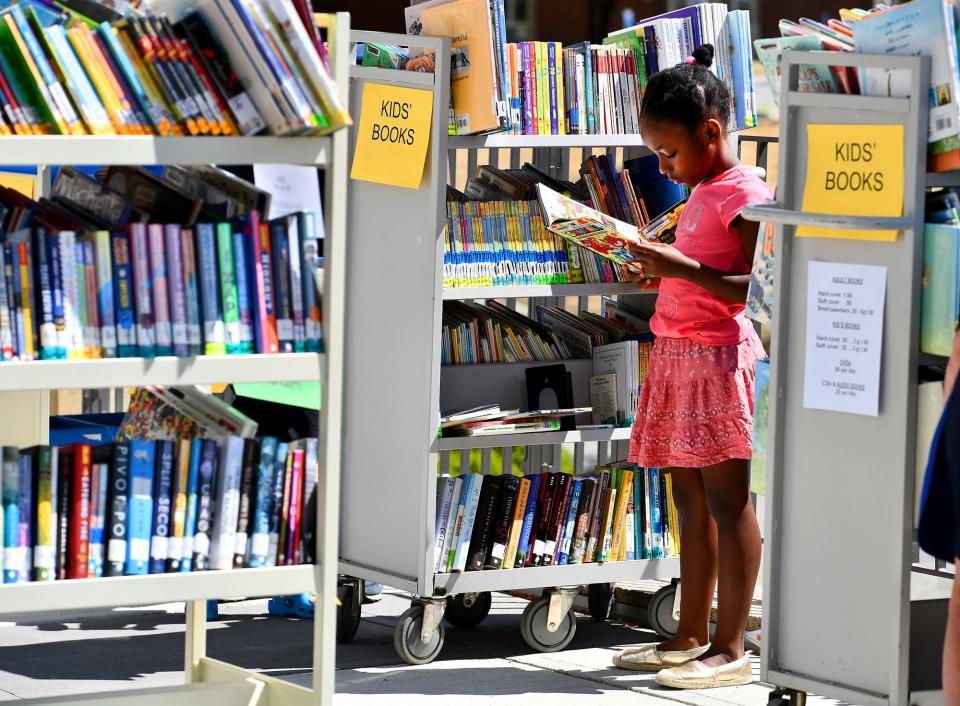 Bria, 9, of Worcester looks through books for sale.