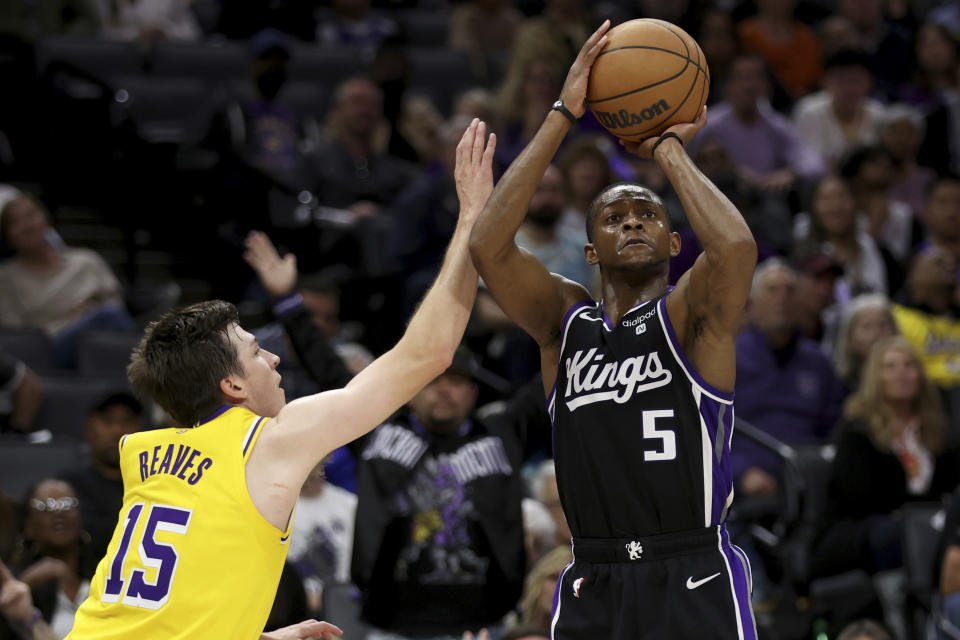 Sacramento Kings guard De'Aaron Fox (5) shoots against Los Angeles Lakers guard Austin Reaves (15) during the second half of an NBA basketball game in Sacramento, Calif, Wednesday, March 13, 2024. (AP Photo/Jed Jacobsohn)