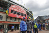 Ukrainian flags are seen outside Wrigley Field as fans arrive for the Chicago Cubs home-opener baseball game against the Milwaukee Brewers, Thursday, April 7, 2022, in Chicago. (AP Photo/Kamil Krzaczynski)