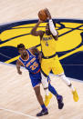 Indiana Pacers guard Victor Oladipo (4) attempts a three-point basket while New York Knicks forward Reggie Bullock (25) works to defend during the first half of an NBA basketball game in Indianapolis, Saturday, Jan. 2, 2021. (AP Photo/Doug McSchooler)