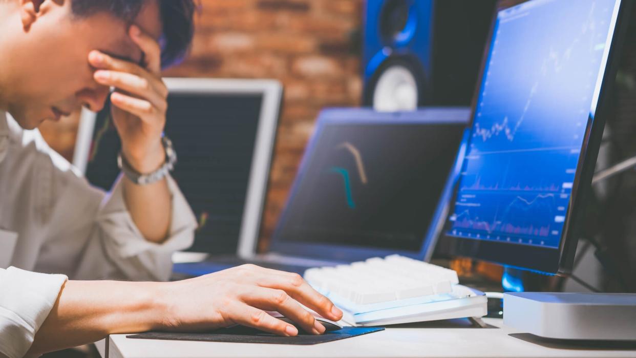 upset asian businessman at desk, depressed by working in office.