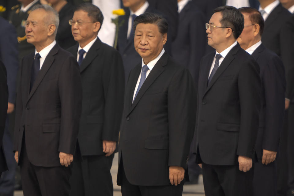 Chinese President Xi Jinping, center, stands during a ceremony to mark Martyr's Day at the Monument to the People's Heroes at Tiananmen Square in Beijing, Friday, Sept. 30, 2022. (AP Photo/Mark Schiefelbein)