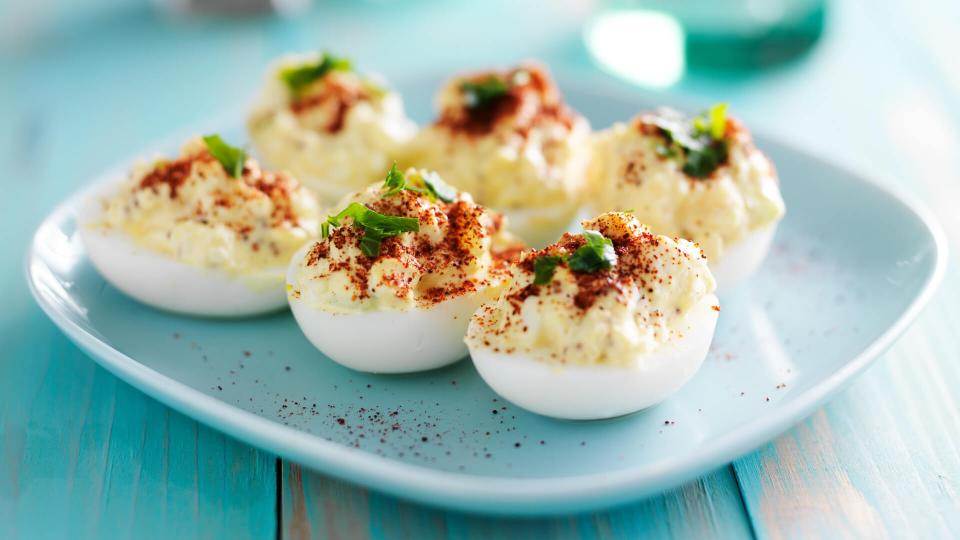 deviled eggs with paprika and green onion garnish.