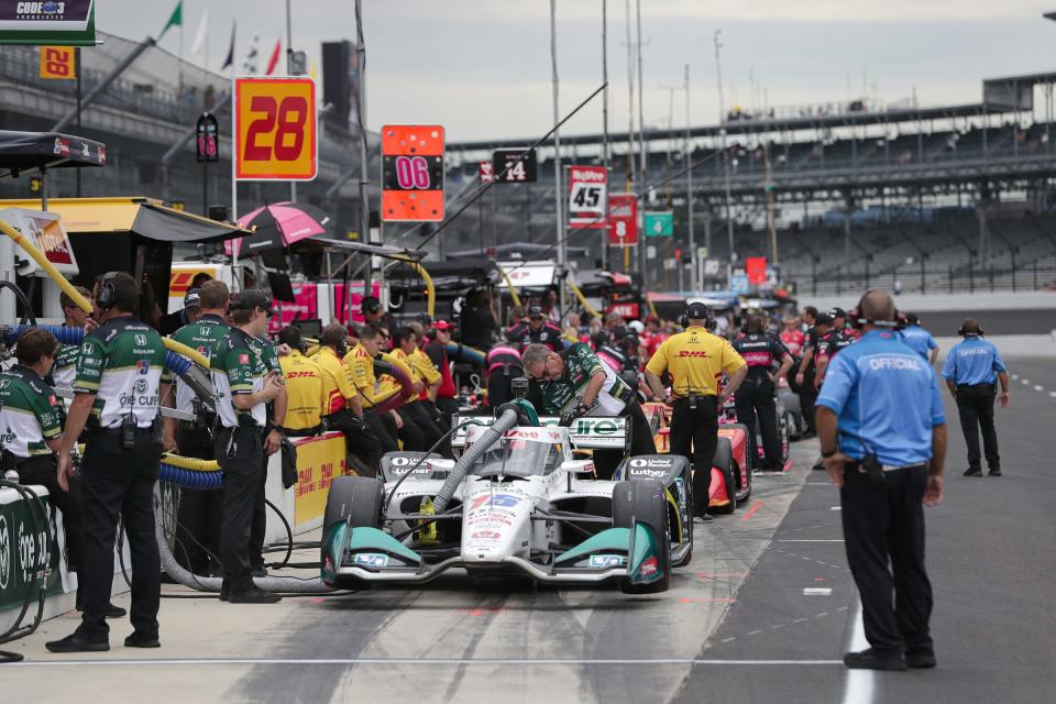 Crew members work on IndyCars in the pits during practice for the IndyCar Grand Prix on Friday, Aug. 13, 2021, at Indianapolis Motor Speedway. 