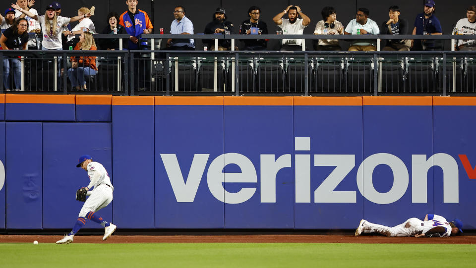 New York Mets outfielder Brandon Nimmo, left, retrieves the ball hit by Miami Marlins' Bryan De La Cruz after outfielder Harrison Bader, right, failed to field it during the fifth inning of a baseball game Tuesday, June 11, 2024, in New York. (AP Photo/Noah K. Murray)