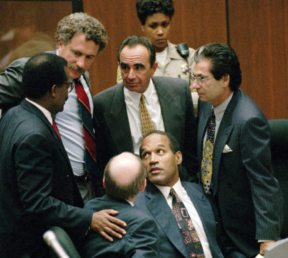 FILE–In this Sept. 28, 1995 file photo, O.J. Simpson is surrounded by his “Dream Team” defense attorneys from left, Johnnie L. Cochran Jr., Peter Neufeld, Robert Shapiro, Robert Kardashian, and Robert Blasier, seated at left, at the close of defense arguments in Los Angeles. (AP Photo/Sam Mircovich, Pool, File)