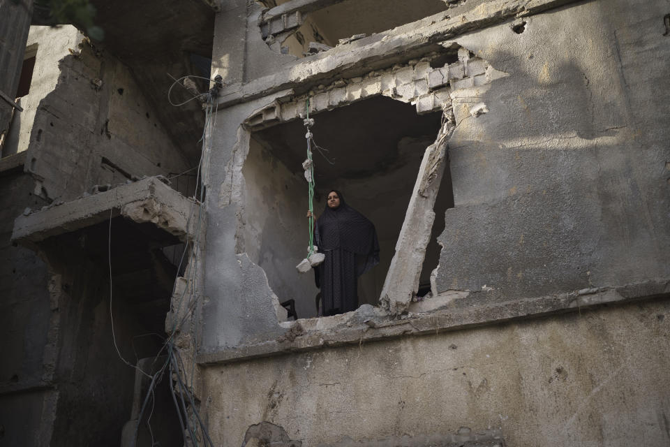 Jawaher Nassir looks out from a room of her home, heavily damaged by airstrikes during an 11-day war between Israel and Hamas, the militant group that controls Gaza, Friday, June 11, 2021, in Beit Hanoun, northern Gaza Strip. “Our memories are here,” she says. (AP Photo/Felipe Dana)