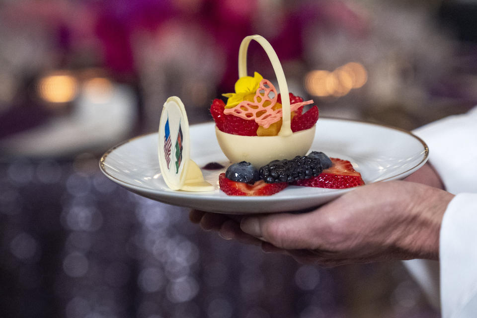 White House Executive Pastry Chef Susie Morrison holds the dessert course, a white chocolate basket with banana ganache, raspberries, peaches, and candied lime zest, during a preview of the State Dinner with Kenya, Wednesday, May 22, 2024, ahead of Thursday evening's State Dinner with Kenya's President William Ruto, at the White House in Washington. (AP Photo/Jacquelyn Martin)