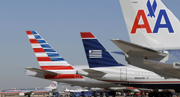 U.S. Airways and American Airlines planes are shown at gates at DFW International Airport Thursday, Feb. 14, 2013, in Grapevine, Texas. The two airlines will merge forming the world's largest airlines.  (AP Photo/LM Otero)